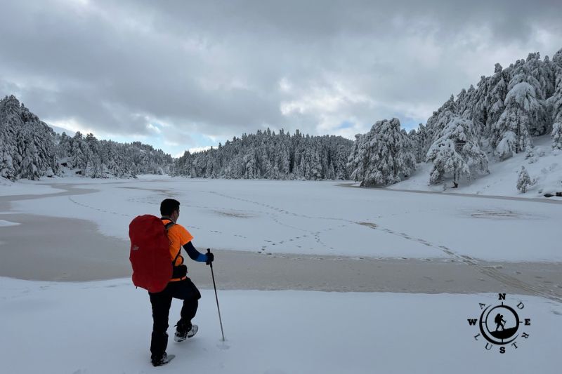 Hiker at frozen Lake Dasiou